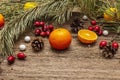 Spirit Christmas background. Fresh mandarins, dog-rose berries, candies, pine branches and cones, artificial snow Royalty Free Stock Photo