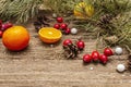 Spirit Christmas background. Fresh mandarins, dog-rose berries, candies, pine branches and cones, artificial snow Royalty Free Stock Photo