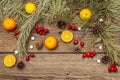 Spirit Christmas background. Fresh mandarins, dog-rose berries, candies, pine branches and cones, artificial snow Royalty Free Stock Photo