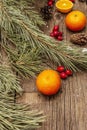 Spirit Christmas background. Fresh mandarins, dog-rose berries, candies, pine branches and cones, artificial snow Royalty Free Stock Photo