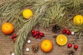 Spirit Christmas background. Fresh mandarins, dog-rose berries, candies, pine branches and cones, artificial snow Royalty Free Stock Photo