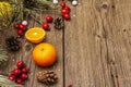 Spirit Christmas background. Fresh mandarins, dog-rose berries, candies, pine branches and cones, artificial snow Royalty Free Stock Photo