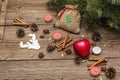 Spirit Christmas background. Gift in sack, New Year tree, apple, candles, spices, deer, cones. Nature decorations, vintage wooden