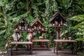 Spirit house and tree roots intertwined. Miniature house for guardian spirit with garland and some wreathes, A dedicated structure