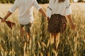 The spirit of travel, freedom and independence. Happy young couple in love running in the field in the sunset light. Messy hair. F Royalty Free Stock Photo