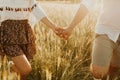 The spirit of travel, freedom and independence. Happy young couple in love running in the field in the sunset light. Messy hair. F Royalty Free Stock Photo