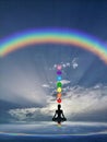 Spiritual background with chakras, human silhouette and rainbow in sea reflection Royalty Free Stock Photo