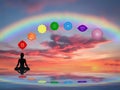 Spiritual background with chakras, human silhouette and rainbow in sea reflection Royalty Free Stock Photo