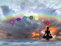 Spiritual background with chakras, human silhouette and rainbow in sea reflection Royalty Free Stock Photo