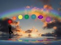 Spiritual background with chakras, human silhouette and rainbow in sea reflection Royalty Free Stock Photo