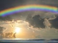 Spiritual background with rainbow in the sunset in sea reflection