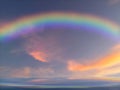 Spiritual background with rainbow in the sunset in sea reflection