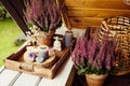 Spiritual home balcony decor with heather flowers, candlelight flame, crystal geodes, crystal wire tree and small Buddha figurine.