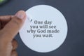 Spiritual inspirational quote - One day you will see why God made you wait. With person holding circle label paper in hand.