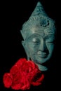 Spiritual love. Beautiful blue buddha head statue with red roses Royalty Free Stock Photo