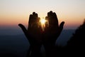 Spiritual prayer hands over sun shine with blurred beautiful sunset background Royalty Free Stock Photo