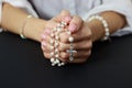 Spiritual prayer to god, with verve or rosary in the hands of a young girl. Black background. Close-up Royalty Free Stock Photo