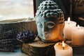 Spiritual ritual meditation face of Buddha ametist candles on old wooden background