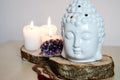 Spiritual ritual meditation face of Buddha ametist candles on wooden white background