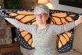 Spiritual senior woman holding dreamy butterfly wings