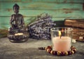 Spiritual still life with candles, beads, statue of Buddha and dry flowers