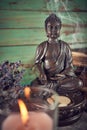 Spiritual still life with candles, beads, statue of Buddha and dry flowers