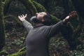 Spiritual zenlike nature love people. One man with closed eyes and outstretching arms in the nature forest green trees scenic