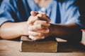 Hands folded in prayer on a Holy Bible in church concept for faith Royalty Free Stock Photo