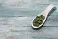 Spirulina,chlorella supplement pills on wooden table. Selective Royalty Free Stock Photo