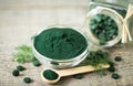 Spirulina tablets and powder in bowls Royalty Free Stock Photo