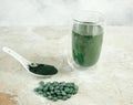 Spirulina tablets, powder and tea on concrete background Royalty Free Stock Photo