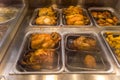 Spit-roasted chickens displayed in thermal counter