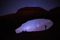 Spitzkoppe national park in Namibia. Woman under Natural Rock Arch gazing at milky way and the stars. Silhouette of lone woman Royalty Free Stock Photo