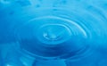 A splash of blue water. A drop of water on a blue background. Splashing, water surface, the funnel Royalty Free Stock Photo