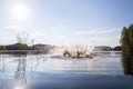 Splash and circles on the water after a man jumped into a clean, forest lake, against the backdrop of trees and the sky. Royalty Free Stock Photo