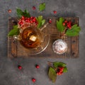 Splash in a cup of tea. Cupcakes on a wooden board. Viburnum leaves and berries. Flat lay, copy space. Gray background Royalty Free Stock Photo