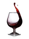 Splash with drops of red wine in a glass. Isolated on white background Royalty Free Stock Photo