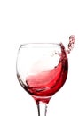Splash of falling red wine in a round glass on a white background Royalty Free Stock Photo