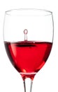 Splash of falling red wine in a round glass on a white background Royalty Free Stock Photo