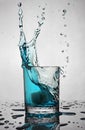 Splash in glass of blue alcoholic cocktail drink with ice cube Royalty Free Stock Photo