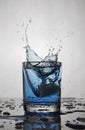 Splash in glass of blue alcoholic cocktail drink with ice cube Royalty Free Stock Photo