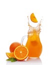 Splash in glass jug of juice with falling slice of orange Royalty Free Stock Photo