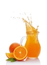 Splash in glass jug of juice with falling slice of orange Royalty Free Stock Photo
