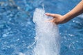 Splash of a jet of clean water from a fountain pouring into the hands of a child. Royalty Free Stock Photo