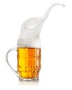 Splash of light beer in faceted mug Royalty Free Stock Photo