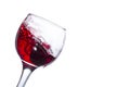 Splash of red wine in a tilted glass with fallen grapes Royalty Free Stock Photo