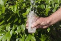 Splash of spring water. Man holding glass and pouring fresh clean water Royalty Free Stock Photo