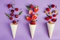 Splash of summer berries from ice cream cones on purple background. Summer time food flat lay Royalty Free Stock Photo