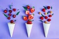 Splash of summer berries - strawberries, raspberries and cherry from ice cream cones on blue background. Summer time Royalty Free Stock Photo