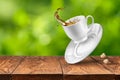 Splash of tea on wooden table against green background Royalty Free Stock Photo
